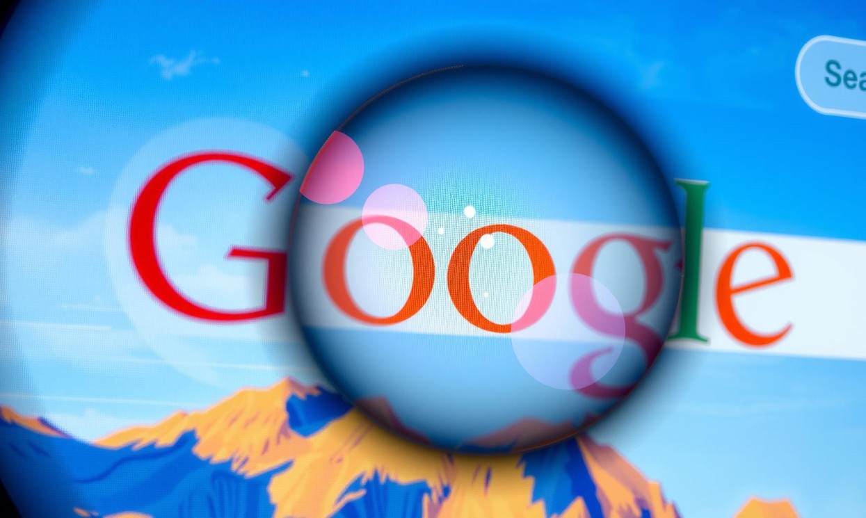 Immagine di un monitor che visualizza un motore il motore sdi ricerca Google con una lente di ingrandimento che si concentra su una specifica parola chiave